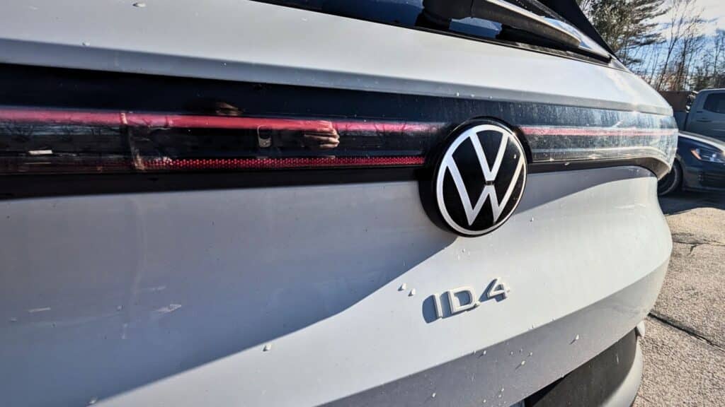 Close-up of Volkswagen ID.4 rear emblem and light bar on a white EV.